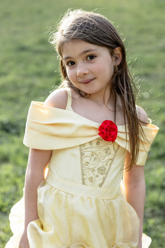 Young girl in yellow Belle inspired dress featuring gold designs and a large red rose in the center.