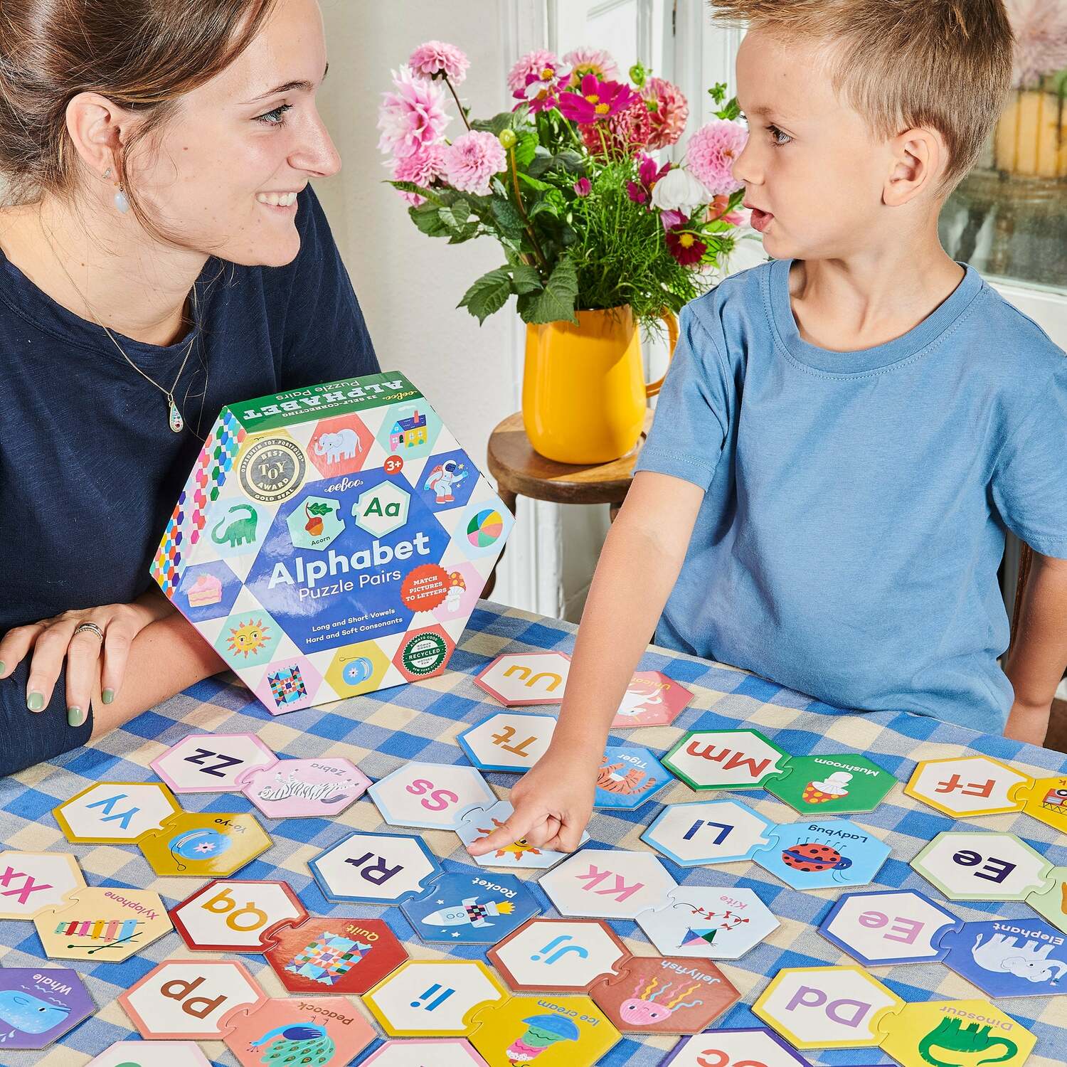 Adult woman and child playing with the alphabet puzzle pairs together