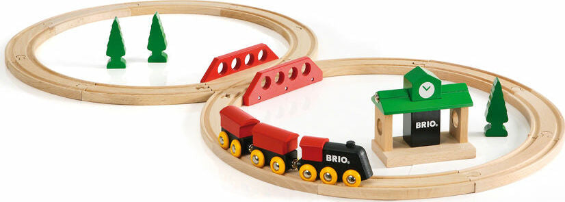 Wooden train set with tracks, trees, and a station on a white background