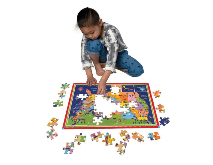 child putting together puzzle of the united states map