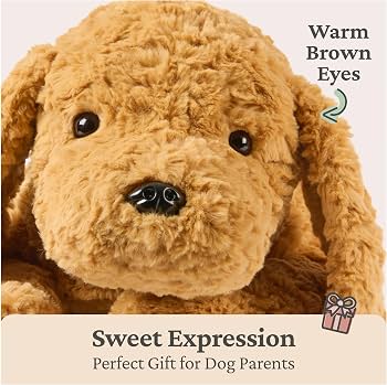 A large, plush golden-brown dog with soft curly fur lies flat on its belly against a plain background. It features long, floppy ears, dark bead eyes, and a dark brown oval nose.