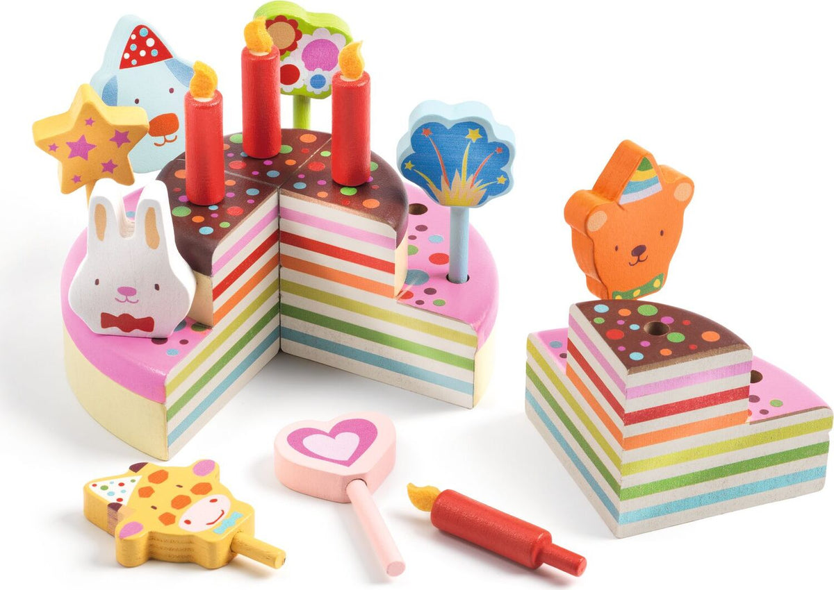 Colorful toy cake set with candles and tools on a white background