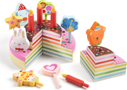 Colorful toy cake set with candles and tools on a white background
