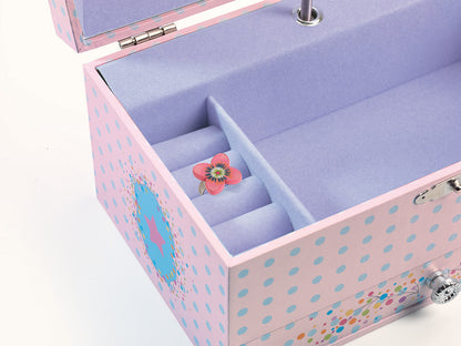 open, light pink wooden jewelry box patterned with light blue polka dots. The inside is lined with soft lavender felt, featuring a main open compartment, ring slots holding a small floral ring, and a silver keyhole on the outer edge.