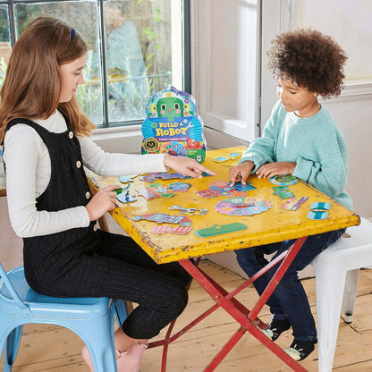 two children sitting at a table playing Build a Robot together