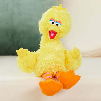 Yellow plush toy with orange feet on a light background