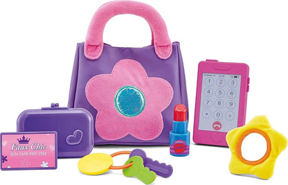 A purple soft purse with a bright pink flower design, accompanied by various pretend accessories including a wallet, a play cellphone, keys, a mirror, and a pretend lipstick.