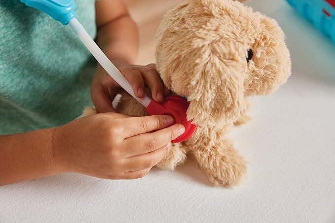 a child pretending to check on the plush dog with a plastic stethoscope 