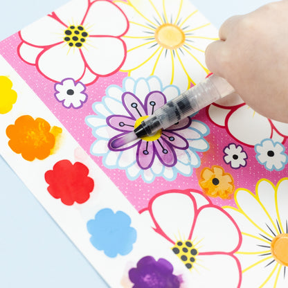 Colorful flower stickers on a sheet with a hand holding a small syringe.