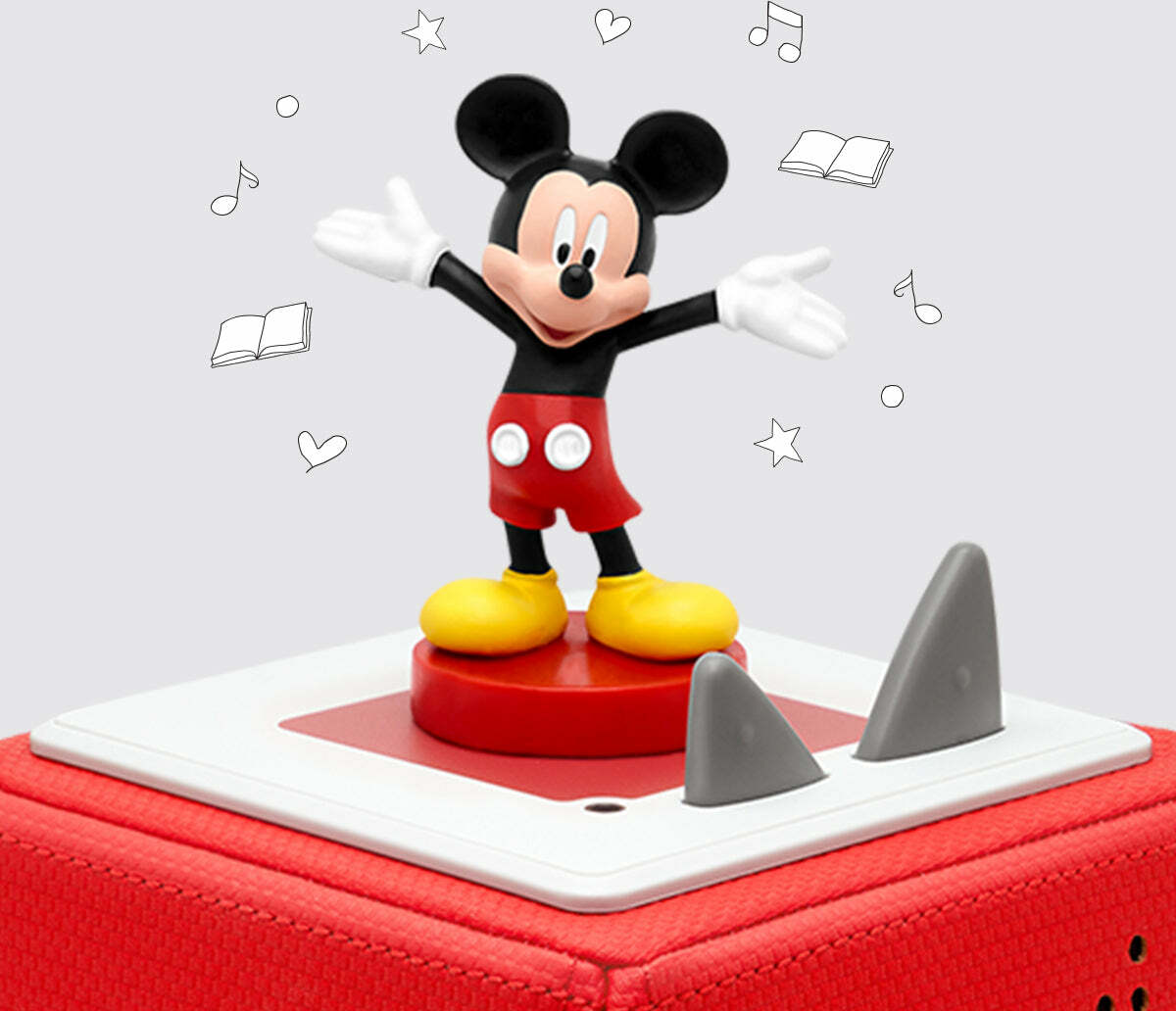 Mickey mouse standing with open arms on a toniebox  set against a light background with line-dawn icons like stars and music notes.