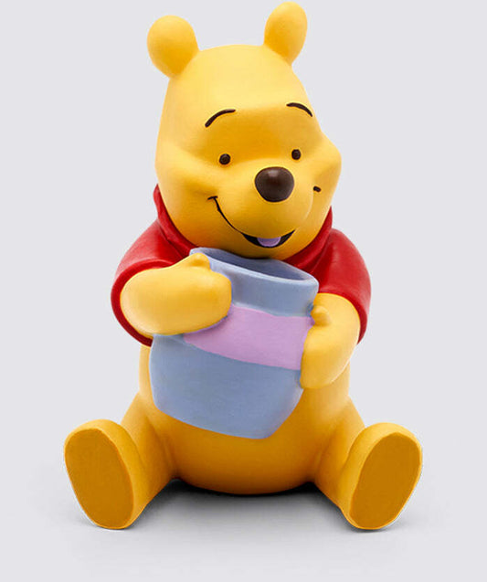A figurine of Winnie the Pooh holding a honey pot, dressed in his classic red shirt.