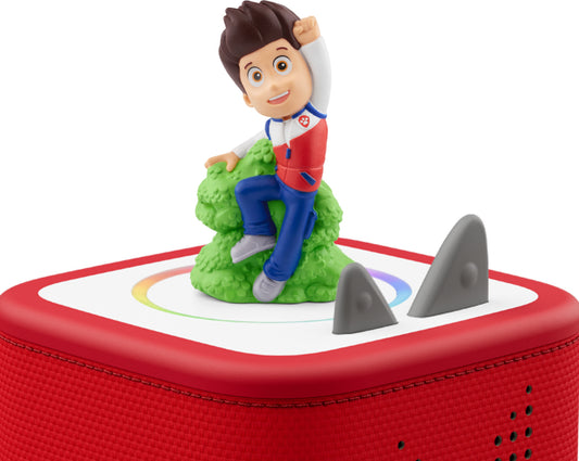 ryder figure sitting on a green rock on top of a red toniebox