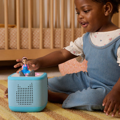 Child playing with a blue toy box in a crib setting