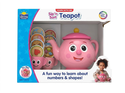 The product image shows the packaged Learn with Me: Sip 'n Sort Teapot toy set against a clean white background. Inside the box is a smiling pink teapot with an interactive nose button, two matching pink teacups, and stacked color-sorting pretend treats.